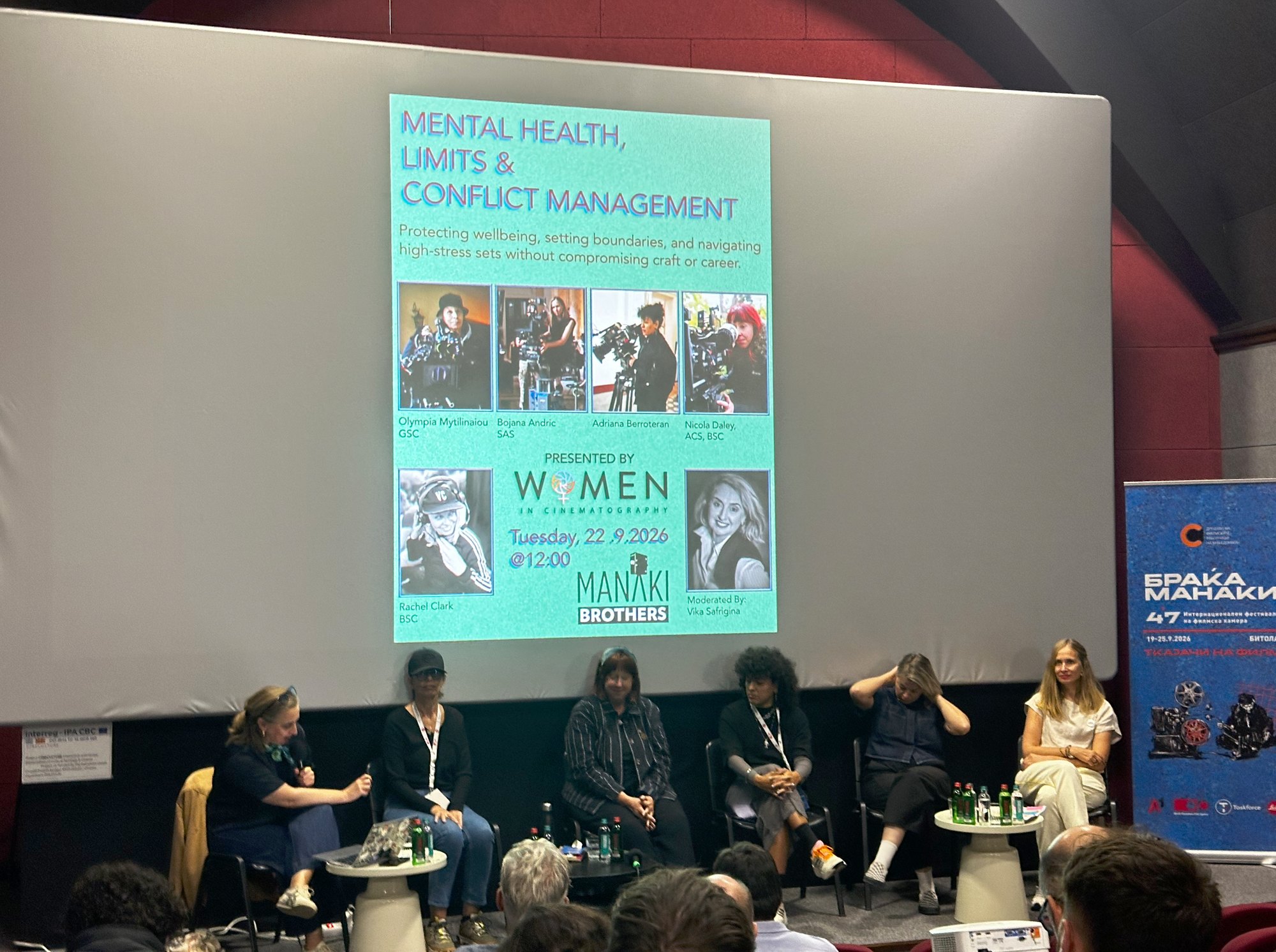 Six femmes assises sur scène sous l’affiche de la table ronde de Women in Cinematography